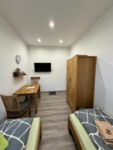 a bedroom with a bed and a table and a tv at Pension Hönel-Hof Bad Schandau in Bad Schandau