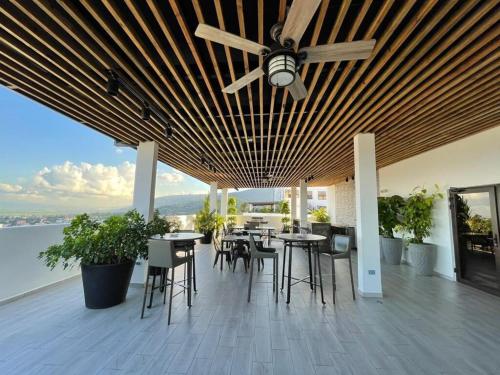 a patio with tables and chairs and a ceiling fan at Spectacular mountain views at San Pedro Sula in San Pedro Sula