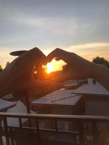 a person making a heart shape with their hands at อินทนนท์แคมป์ปิ้ง เขื่อนสิรินธร in Sirindhorn
