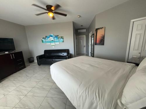 a bedroom with a white bed and a ceiling fan at Grace Bay Suites in Grace Bay
