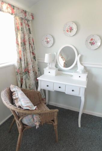 a white dressing table with a mirror and a chair at Das Bärenhaus in Bergen