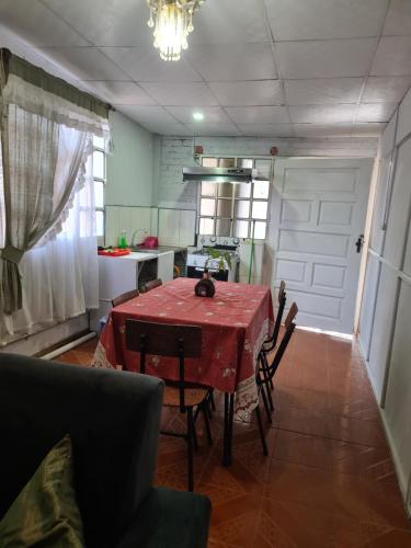 a dining room with a table and chairs and a kitchen at Zeus cómodo e Imperdible in Cochabamba