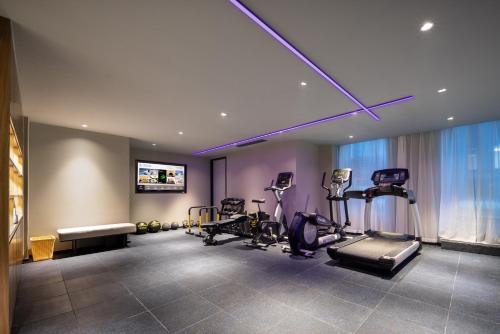 ein Fitnessstudio mit Laufbändern und Trainingsgeräten in einem Raum in der Unterkunft Atour Hotel Hangzhou Binjiang Yuanlun Building in Hangzhou