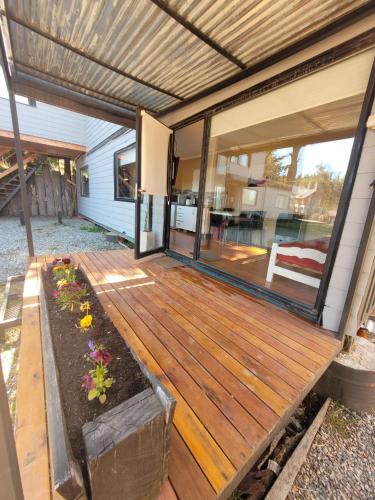 an open porch with a wooden deck with flowers at Pueblo Patagonia in Villa La Angostura