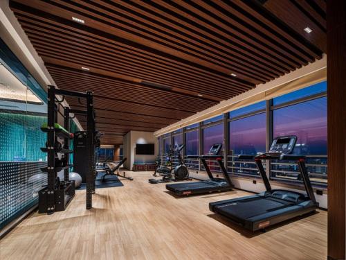 a gym with a row of treadmills and exercise bikes at Hilton Garden Inn Hefei High-Tech Zone in Hefei