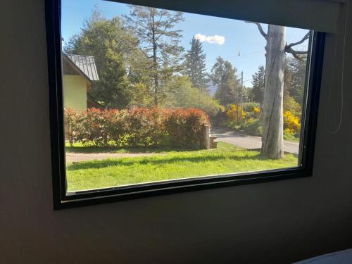 a window in a room with a view of a yard at Pueblo Patagonia in Villa La Angostura