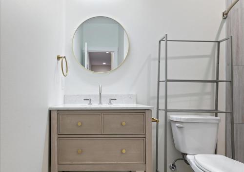 Un baño con lavabo, inodoro y espejo. en Fall at Golden Goose including King Bed, Parking, Security and Laundry, en Evansville
