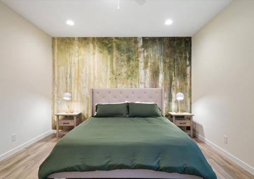 Un dormitorio con una cama verde con dos mesitas de noche. en Fall at Golden Goose including King Bed, Parking, Security and Laundry, en Evansville
