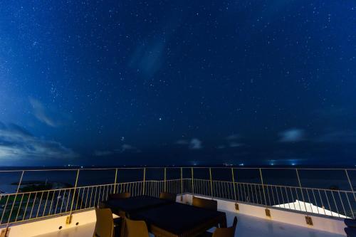 a view of the ocean from a balcony at night at クリスタルヴィラ南城 in Azama