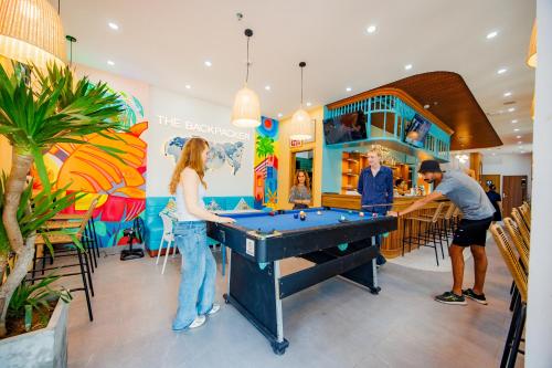 a group of people playing pool in a store at The BackPacker Hotel in Da Nang