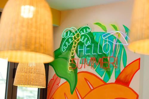 a room with a hello summer sign on the wall at The BackPacker Hotel in Da Nang