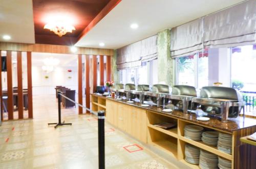 a restaurant with a counter with plates on it at Horison Altama Pandeglang in Pandegelang