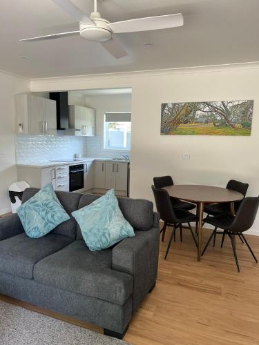 a living room with a couch and a table at Willow Dene Holiday Apartments in Bright