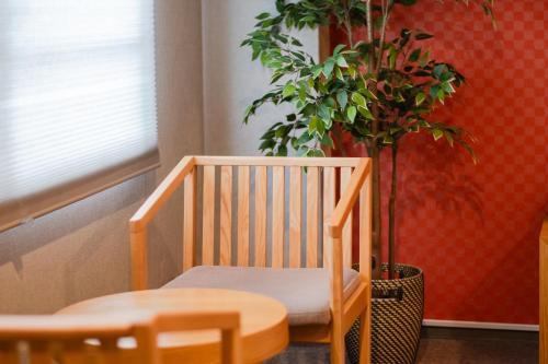 a wooden chair sitting next to a potted plant at Hotel Neiraku in Nara