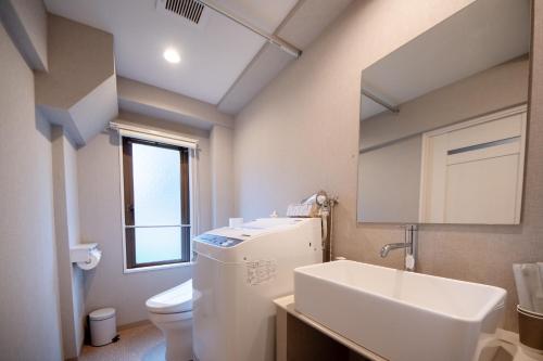 a bathroom with a sink and a toilet and a mirror at Hotel Neiraku in Nara