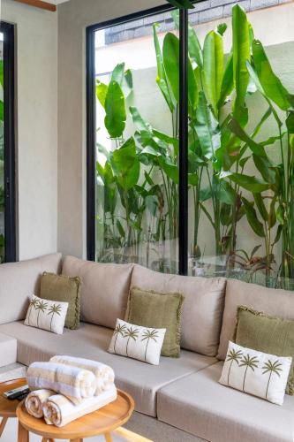 a living room with a couch and a large window at Nanna Villa Unit 2 by Betterplace in Tumbak Bayuh