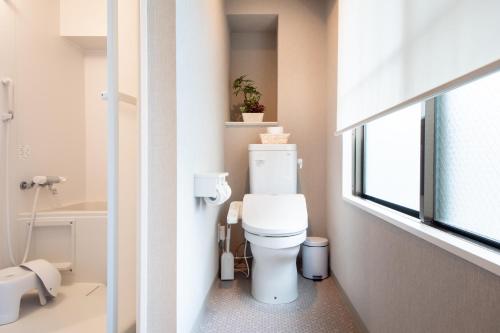 a bathroom with a white toilet and a window at Hotel Neiraku in Nara