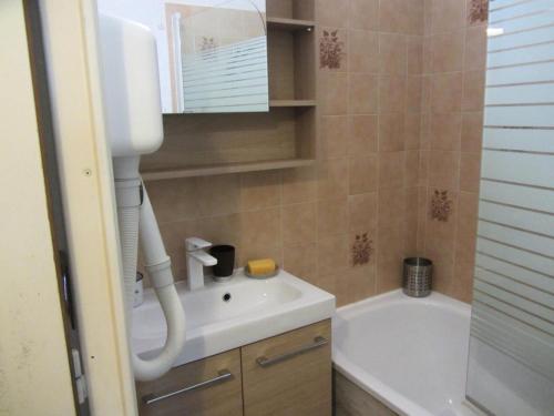 une salle de bain avec un lavabo blanc et une baignoire dans l'établissement Résidence Combettes - Combettes E288 MAE-5071, aux Contamines-Montjoie