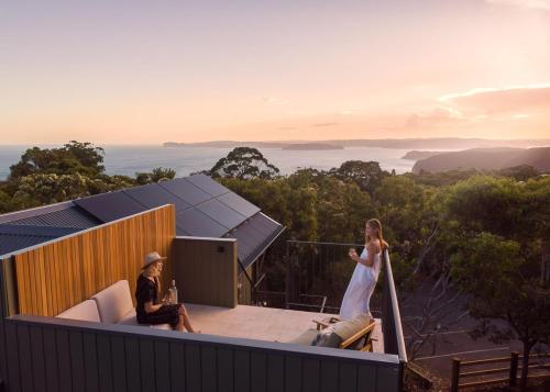 a bride and groom standing on the roof of a house at Bells at Killcare Boutique Hotel, Restaurant & Spa in Killcare
