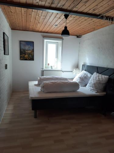 a large bed in a room with a window at Hyggeligt hus på landet in Ansager