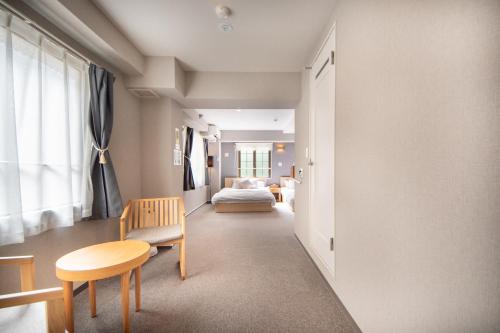 a room with a bed and a table and a chair at Hotel Neiraku in Nara