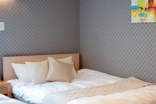 a bedroom with a bed with white sheets at Hotel Neiraku in Nara