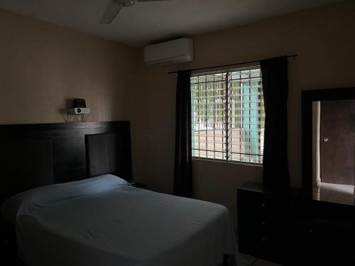 a bedroom with a bed and a window at Casa Arboledas in Manzanillo