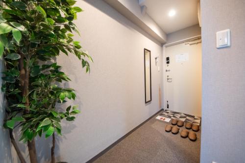 a hallway with a potted tree in a building at Hotel Neiraku in Nara