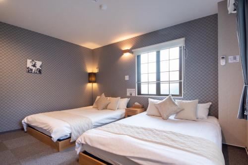 a hotel room with two beds and a window at Hotel Neiraku in Nara