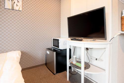 a television on a white table in a bedroom at Hotel Neiraku in Nara