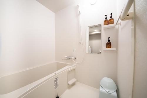 a white bathroom with a sink and a mirror at Hotel Neiraku in Nara