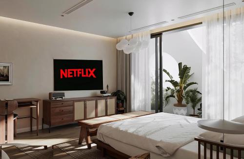 a bedroom with a bed with a netflix sign on the wall at The Hota House in Hanoi