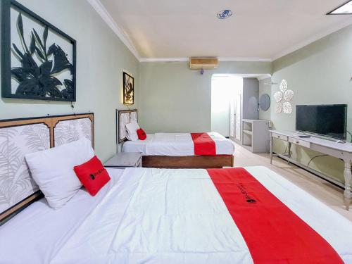 a hotel room with two beds and a television at RedDoorz near Stadion Semeru Lumajang Jawa Timur in Lumajang