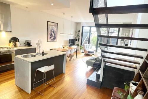 a kitchen and living room with a spiral staircase at TWO FIVE ZERO RICHMOND four bedroom cityviews lockup garage in Melbourne