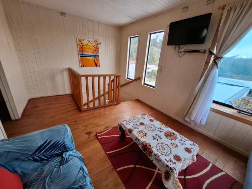 a living room with a table and a tv at Cabañas Eben Ezer in Queule