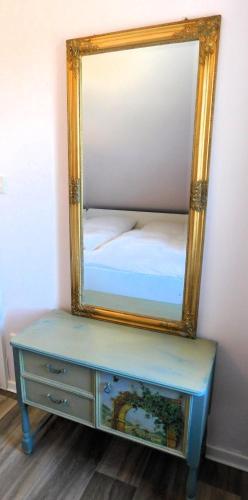 a mirror on top of a dresser with a bed at Das Bärenhaus in Bergen