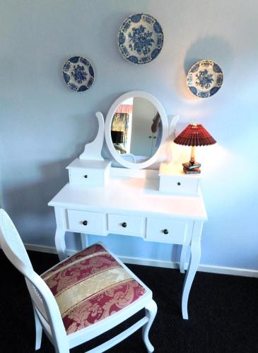 a white dressing table with a mirror and a chair at Das Bärenhaus in Bergen