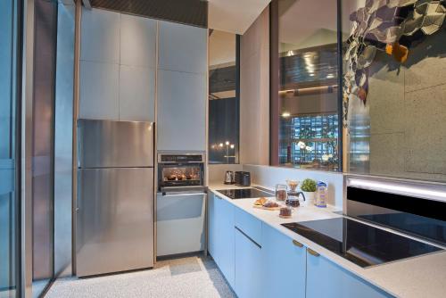 a kitchen with blue cabinets and a stainless steel refrigerator at Citadines Raffles Place Singapore in Singapore