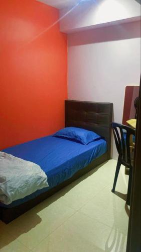 瓜拉丁加奴Cozy single bedroom with shared bathroom的卧室里有一张床，墙壁是橙色的