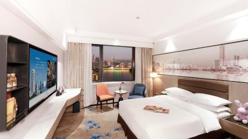 a hotel room with a large bed and a tv at Hotel Landmark Canton in Guangzhou