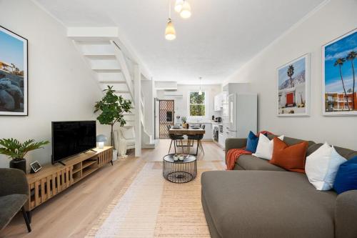 Henley Beach SouthにあるHacienda at Henley - 2BR, Wi-Fi, Workspaceのソファとテレビのあるリビングルーム