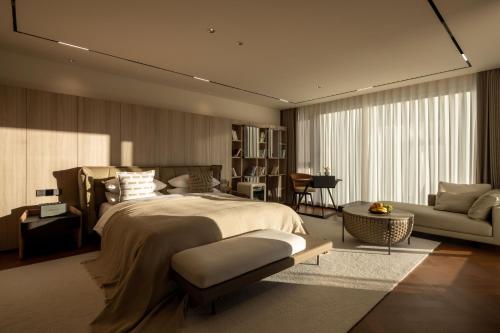 a bedroom with a large bed and a living room at Taohuawu Mountain Luxury Villa Hotel in Lijiang