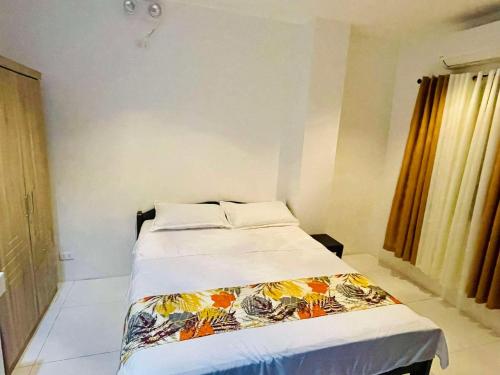 a bedroom with a bed with a colorful blanket on it at Mont Ville Guesthouse in Legazpi