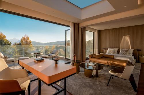 a living room with a bed and a large window at Taohuawu Mountain Luxury Villa Hotel in Lijiang