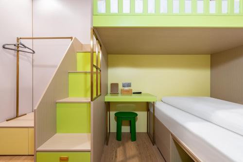 a room with a bunk bed and a green stool at Lemon Hotel - Hangzhou West Lake Fengqi Road in Hangzhou