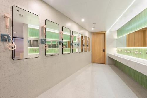 a hallway with a row of mirrors on a wall at Lemon Hotel - Hangzhou West Lake Fengqi Road in Hangzhou