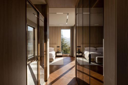a bedroom with two beds and a mirror at Taohuawu Mountain Luxury Villa Hotel in Lijiang
