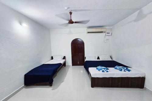 a bedroom with two beds and a ceiling at Beach Queen By The Sea in Calangute