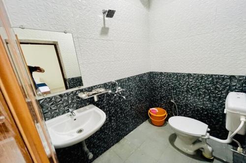 a bathroom with a sink and a toilet and a mirror at Beach Queen By The Sea in Calangute