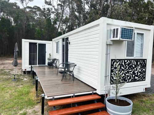 a white tiny house with a wooden deck at Stanthorpe Country Retreat 'Ash Haven' in Greenlands
